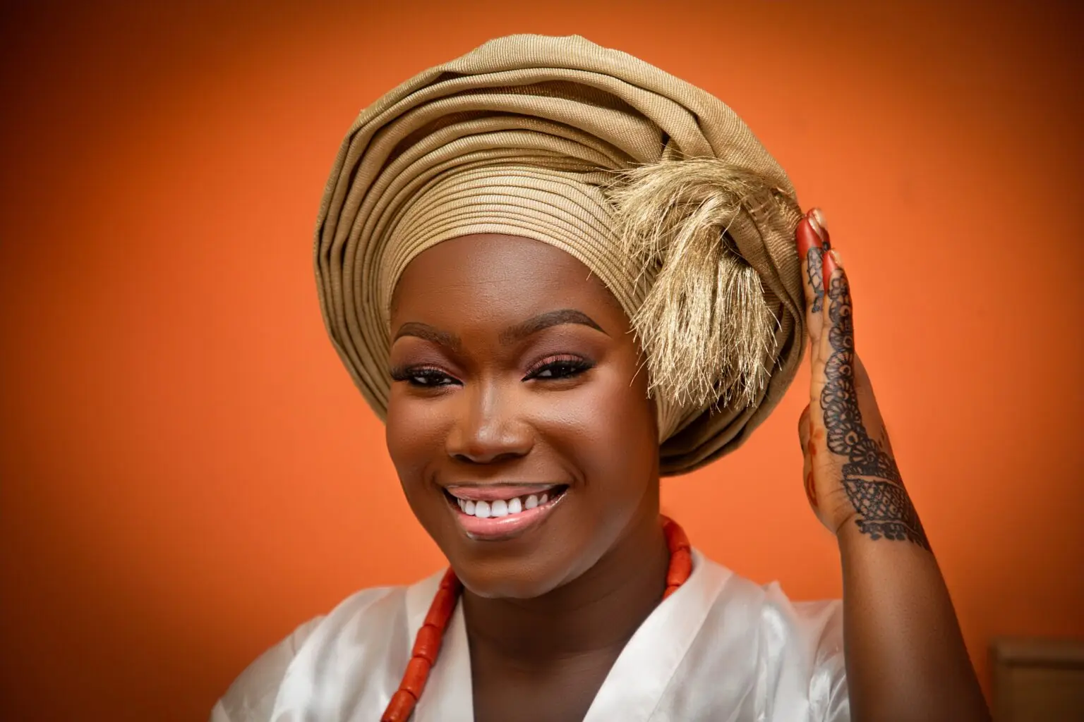Smiling Nigerian woman wearing a gele, feeling healthy and confident